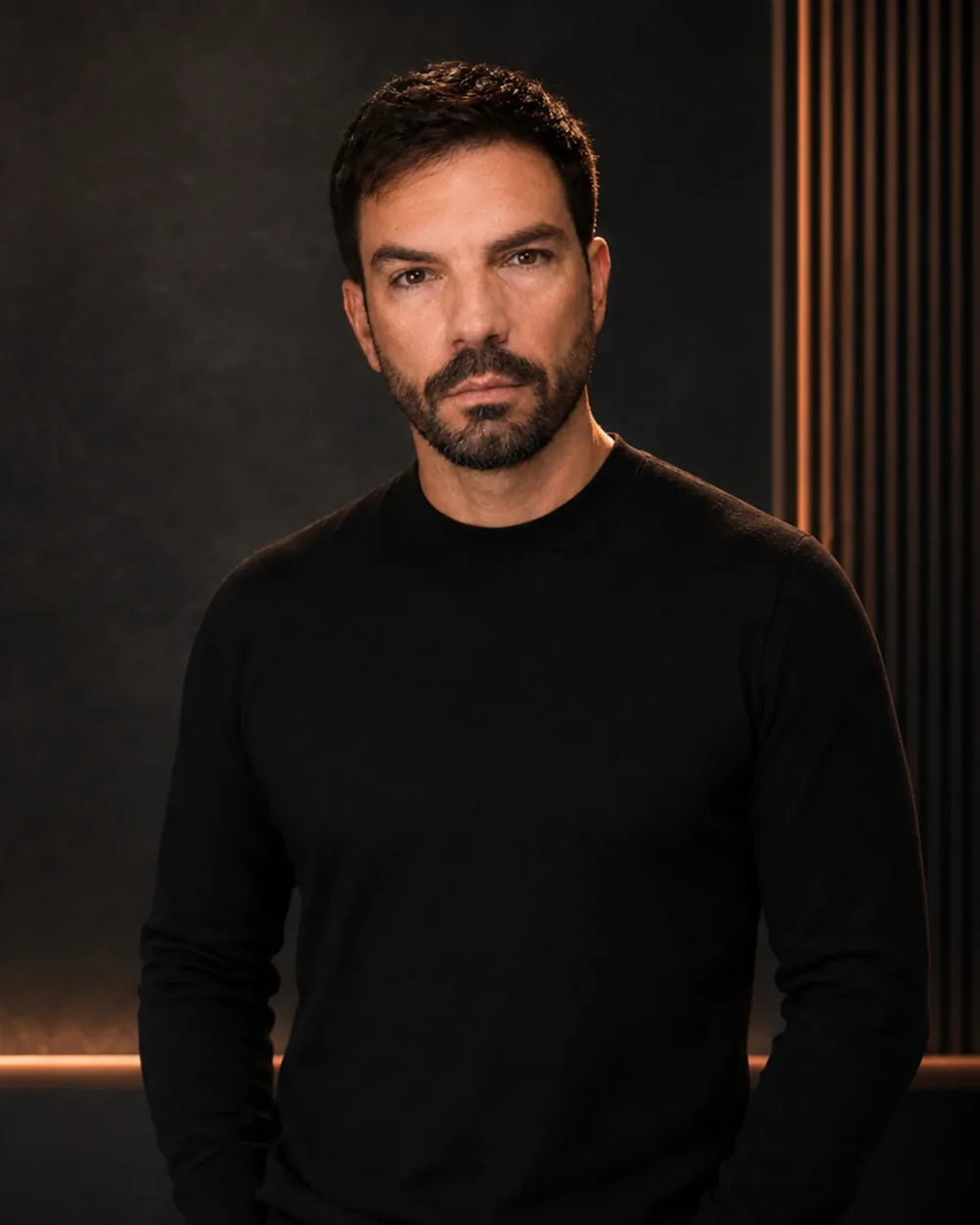 Constan, creador de Secretos del Cuerpo, retratado en plano americano con jersey negro ante la pared oscura del estudio SDC.